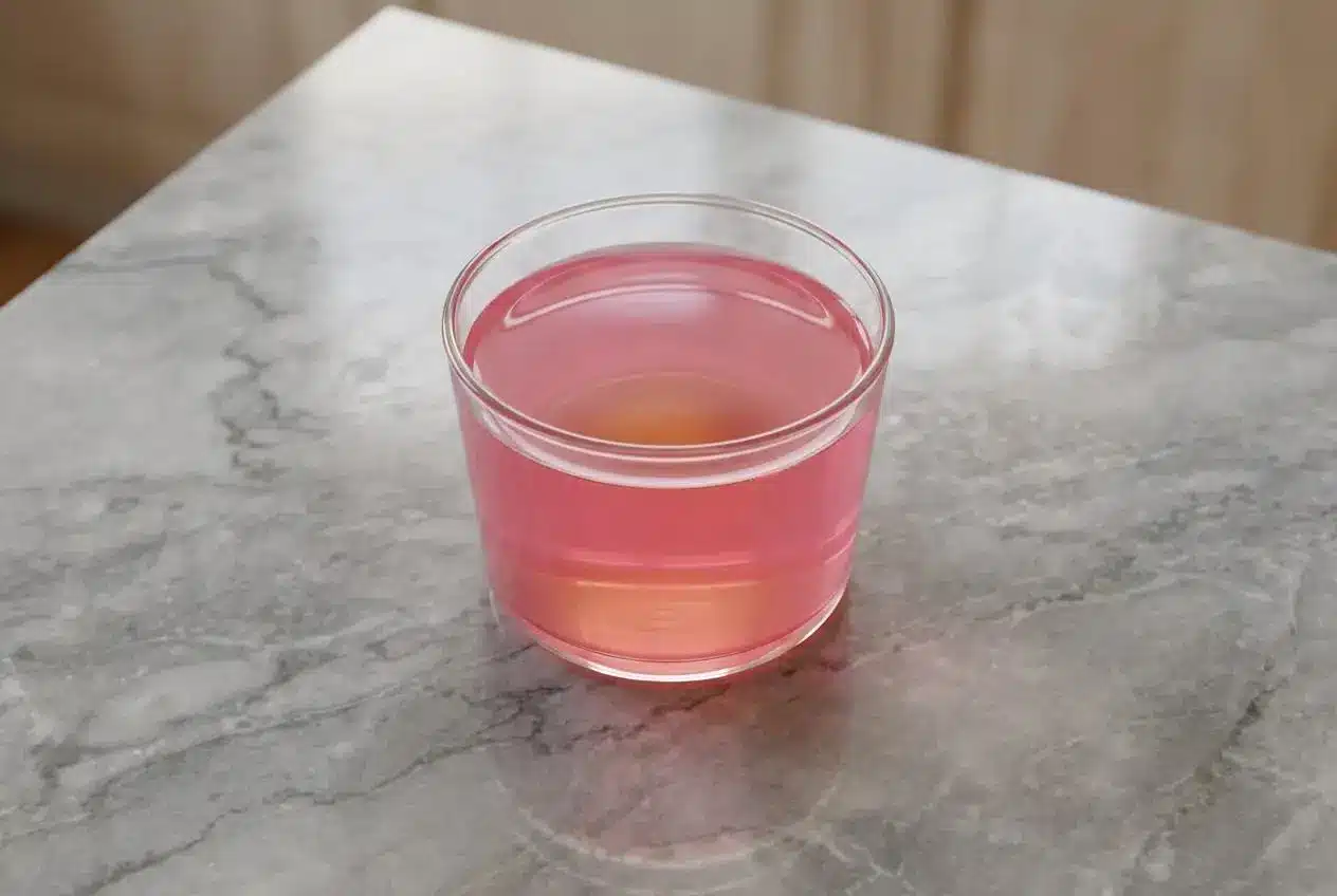 A clear glass dish holding a vibrant Dr Oz Pink Gelatin Recipe, infused with the warm spice of ginger and cinnamon.